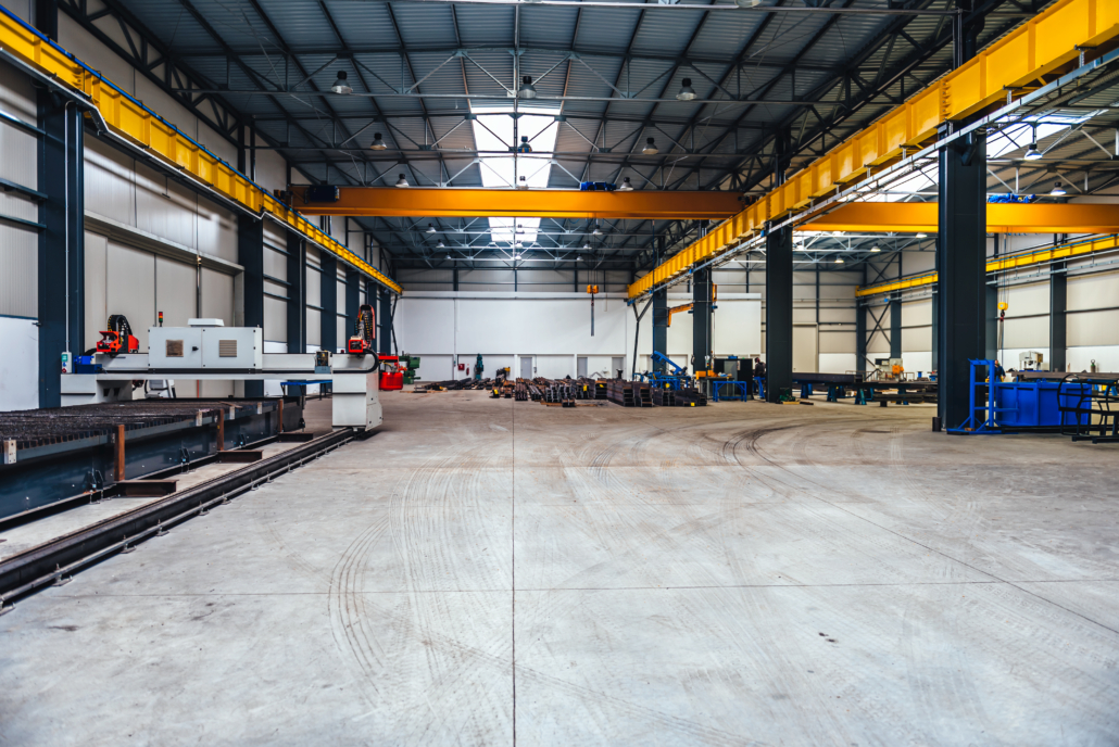 Big industrial hall with CNC Plasma laser cutter machine and metal profiles
