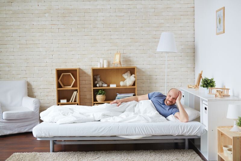 Young man in bed relaxing in the morning