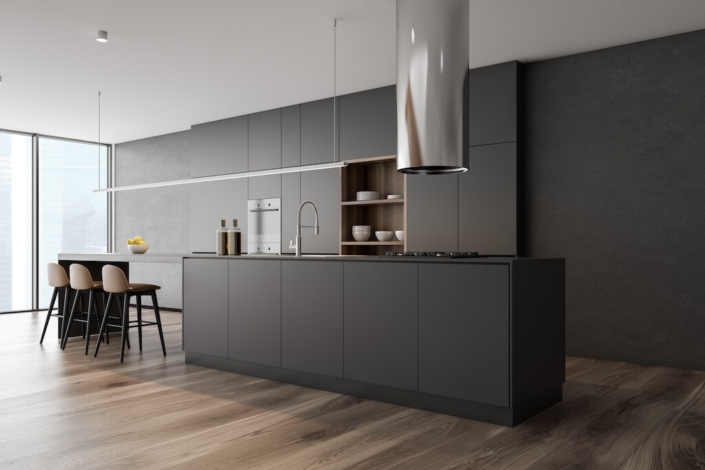 Corner of panoramic kitchen with concrete walls, wooden floor, dark gray island with built in sink and cooker, gray cupboards and bar with stools. 3d rendering