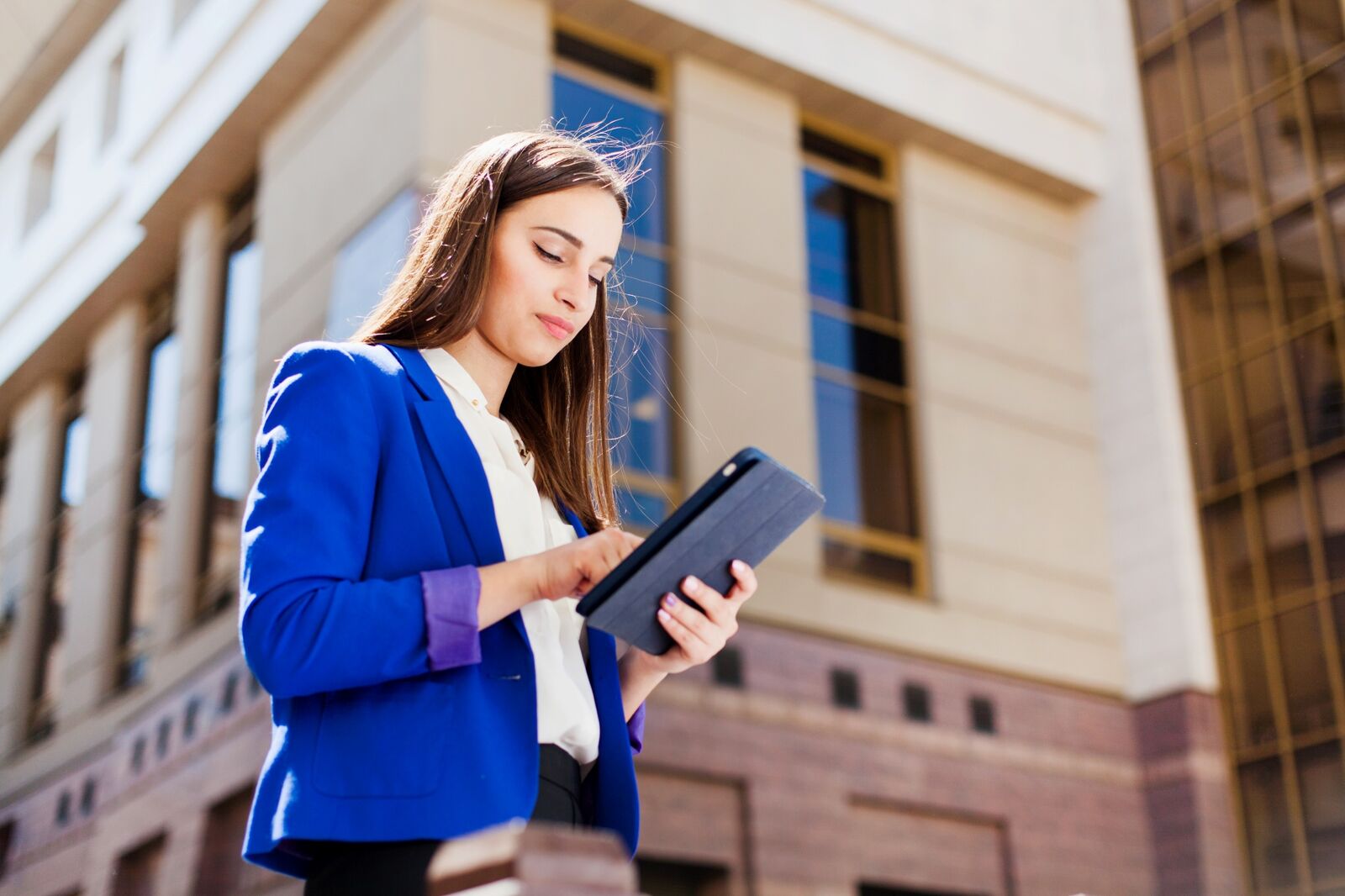 girl checks her tablet standing street